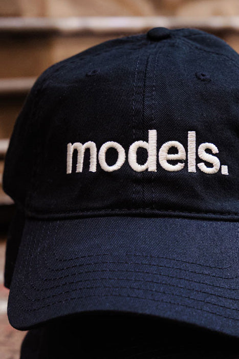 MDC Dad's Cap White on Black close-up of embroidered Models. logo